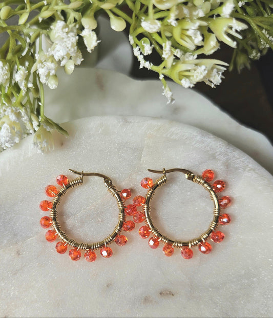 Argollas Flamboyán de Mereki: aros de acero inoxidable tejidos a mano con alambre AAA y cristales color naranja flamboyán.