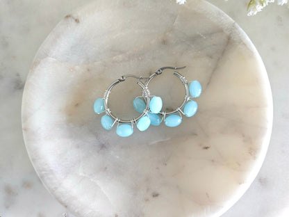Aros plateados de acero inoxidable con delicados cristales azul cemento envueltos con alambre AAA plateado.